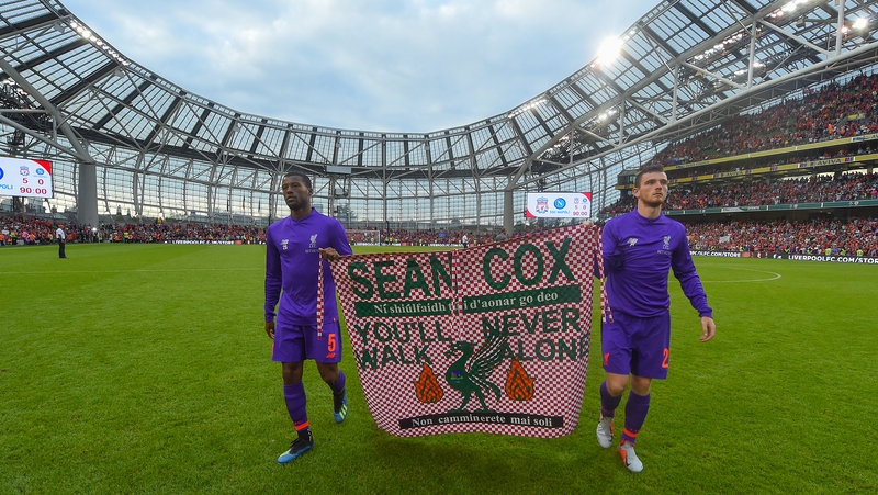 Liverpool players Gini Wijnaldum and Andy Robertson hold up a banner in support of Sean Cox at the Aviva Stadium