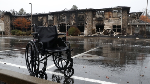 A wheelchair sits in front of a senior living facility that was destroyed by fire in Paradise, California