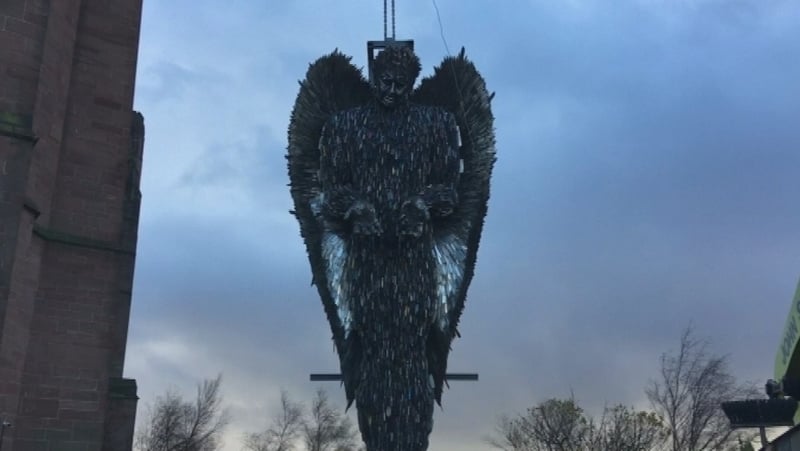 The sculpture includes machetes, meat cleavers, swords, and kitchen knives