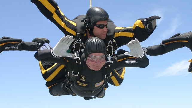 Harnessed to Staff Sergeant Bryan Schell George HW Bush parachutes in celebration of his 80th birthday in 2004