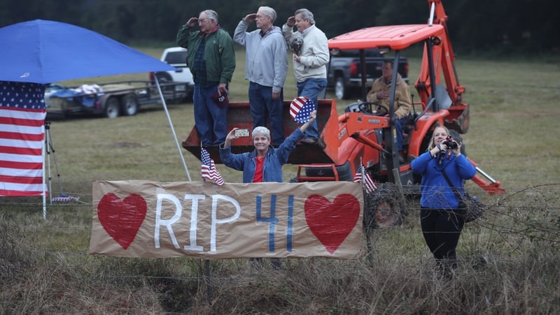 Members of the public line the route to pay their respects as the train carrying George HW Bush passes by in Texas