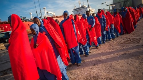 Migrants are seen waiting in a queue to enter a tent of the Spanish Red Cross after their arrival at the Port of Malaga in Spain