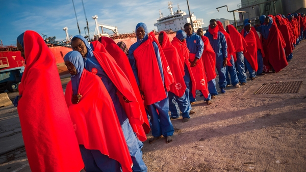 Migrants are seen waiting in a queue to enter a tent of the Spanish Red Cross after their arrival at the Port of Malaga in Spain
