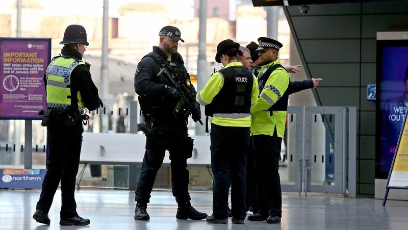 Armed police officers stand guard at Manchester's Victoria Metrolink station today