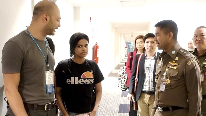 Rahaf Mohammed al-Qunun (C) speaks to Thai officials at a transit hotel near Bangkok