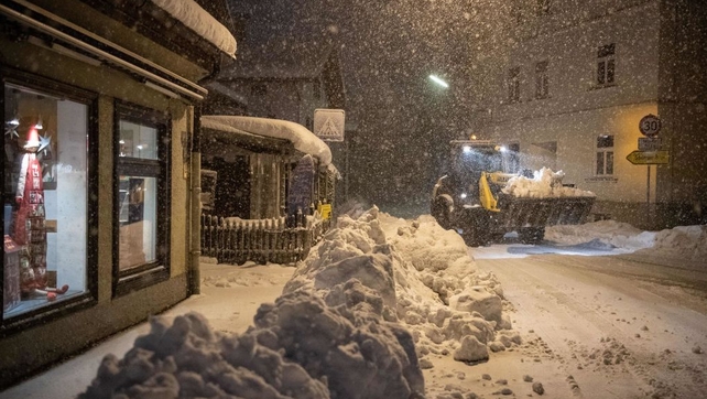 A wheel loader transports snow to clear the streets in Miesbach, southern Germany, during heavy snowfall