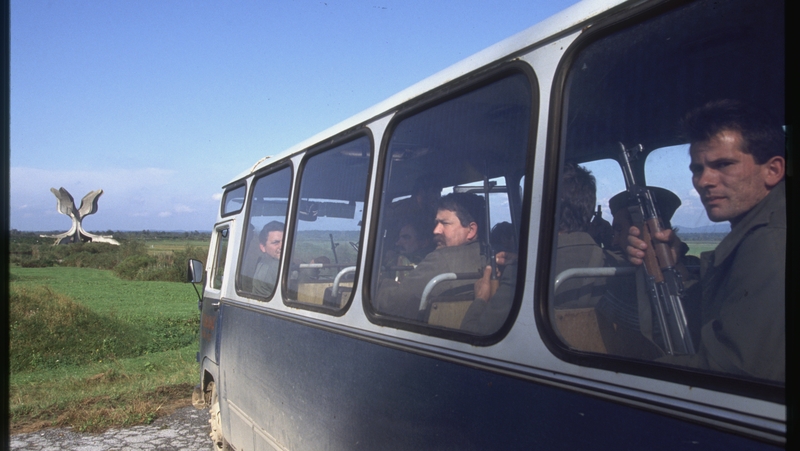 Soldiers on a bus during the Yugoslavian Civil War look out at a memorial erected for the dead in the Jasenovac concentration camp. Photo: Jacques Langevin/ Sygma/Sygma via Getty Images