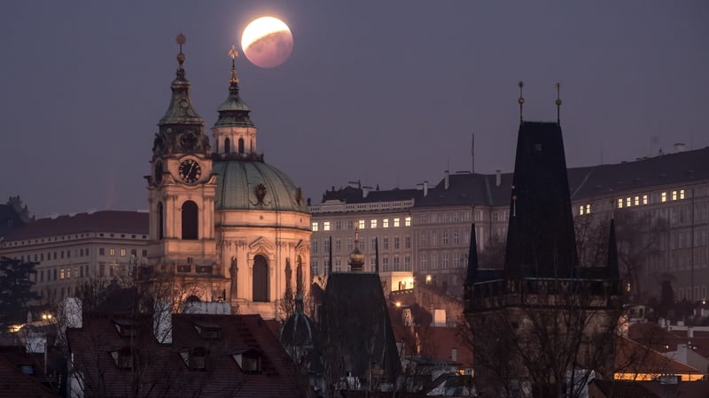 The so-called 'super blood wolf moon' is seen over the Church of Saint Nicholas in Prague, Czech Republic
