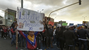 <p>A protester holds a sign calling for freedom for his country</p>