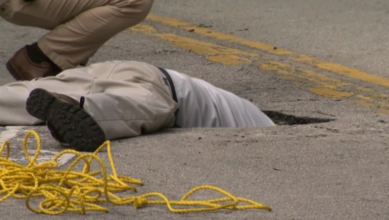 Investigators take a look inside the hole near a branch of Chase Bank
