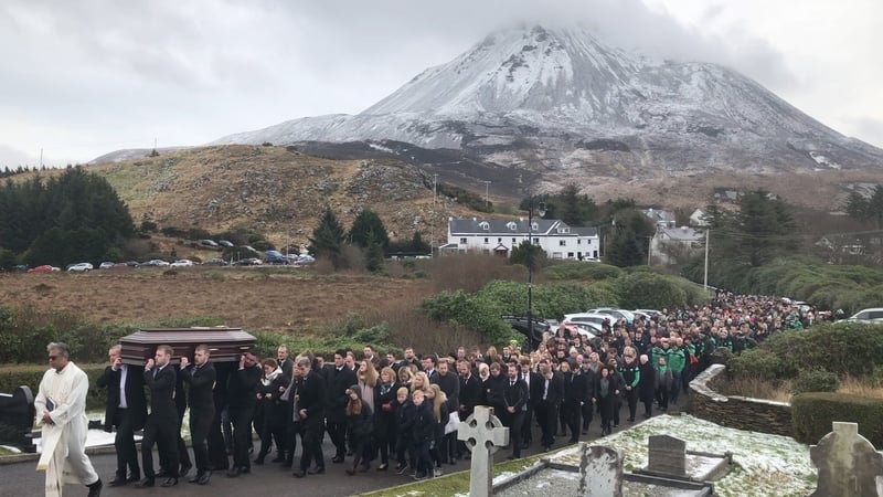 A priest leads mourners outside the Church of the Sacred Heart in Dún Lúiche at the funeral of Mícheál Roarty