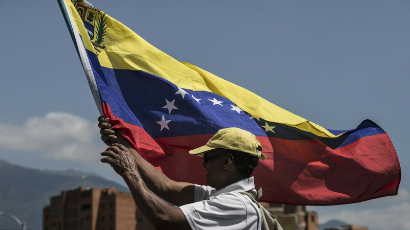 A Venezuelan man holds a flag during a protest against Nicolas Maduro's government in Caracas