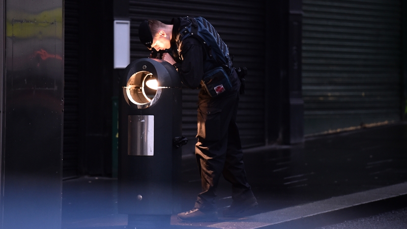 A bomb disposal officer checks for further devices as forensic officers inspect the remains of a van used in a car bomb attack outside Derry Court House. Photo: Charles McQuillan/Getty Images