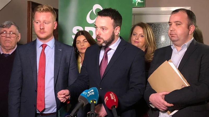 SDLP leader Colum Eastwood (centre) speaks to the media after the vote