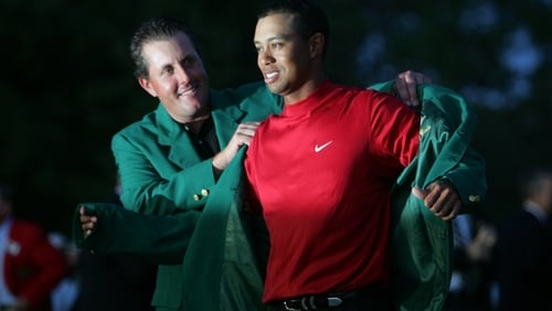 Phil Mickelson helps Tiger Woods into the green jacket after his Masters play-off victory in 2005