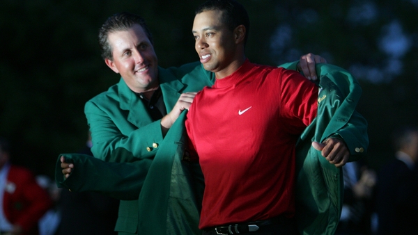 Phil Mickelson helps Tiger Woods into the green jacket after his Masters play-off victory in 2005