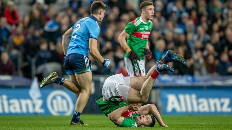 David Byrne of Dublin watches as Mayo's Brian Reape goes head over heels