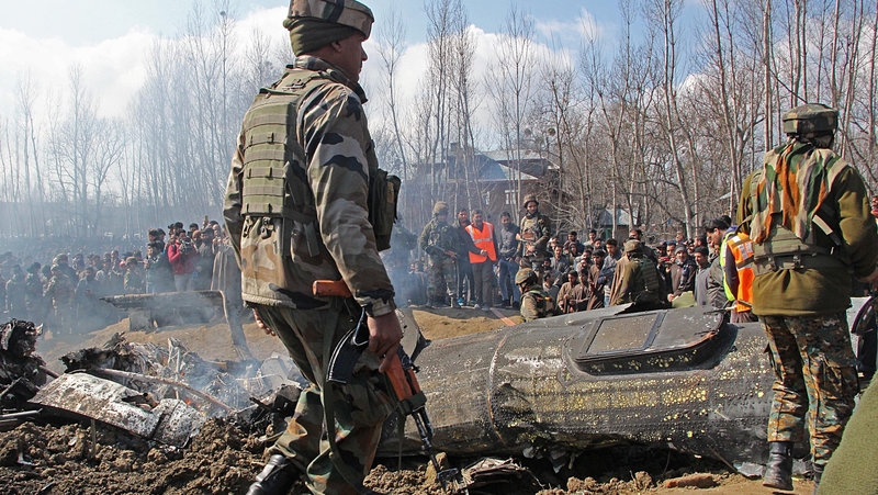Indian army and locals stand near the wreckage of the Indian military aircraft which crashed in central Kashmir's Budgam last month