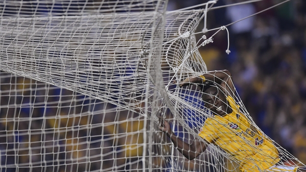 Julián Quiñones of Tigres gets caught in the net during his side's game with Pachuca in Mexico