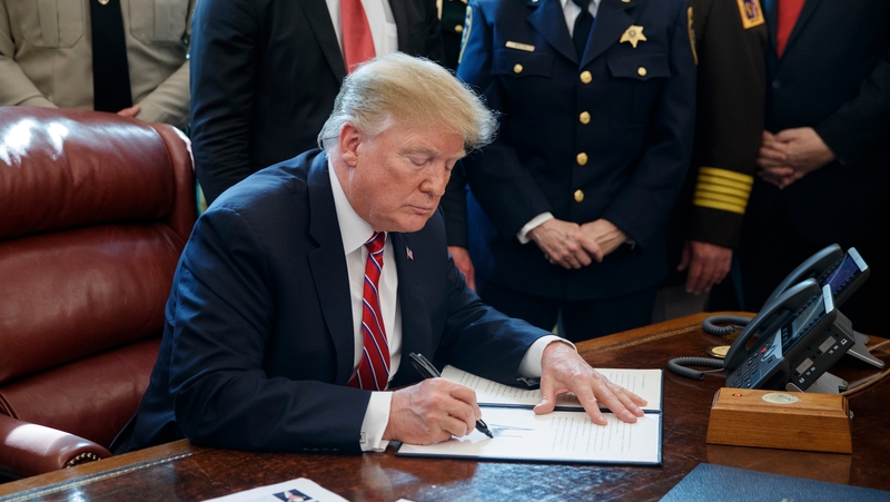 Donald Trump signs the veto in the Oval Office of the White House