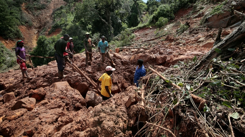 People search for the body of a young man who died after Cyclone Idai hit the Chimanimani in Zimbabwe