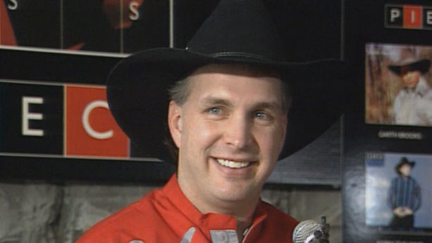 Garth Brooks in a red shirt and black cowboy hat