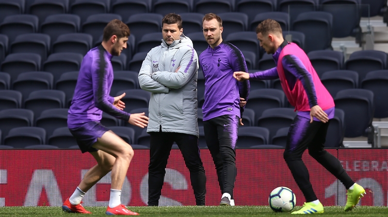 Mauricio Pochettino (2nd from L) and Christian Eriksen (2nd from R) look on during Tottenham training