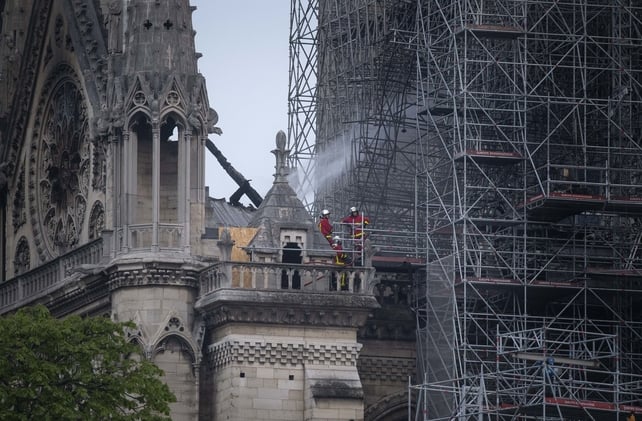 Firefighters in the remains of the Notre-Dame Cathedral following the fire which destroyed much of the building
