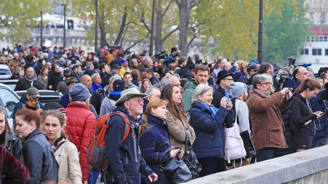 A crowd of people look over towards the remains of the 850-year-old UNESCO world heritage landmark
