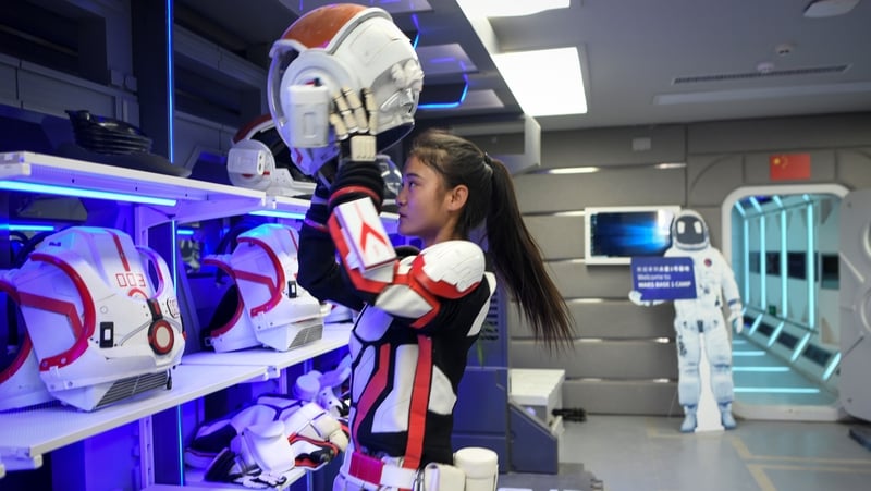 Teenagers use spacesuits to go on treks outside the base