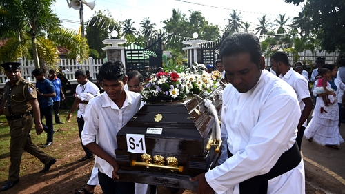 Priests and relatives carry the coffin of a bomb blast victim after a funeral service at St Sebastian's Church in Negombo