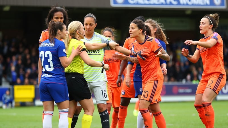 Players surround referee Sara Persson