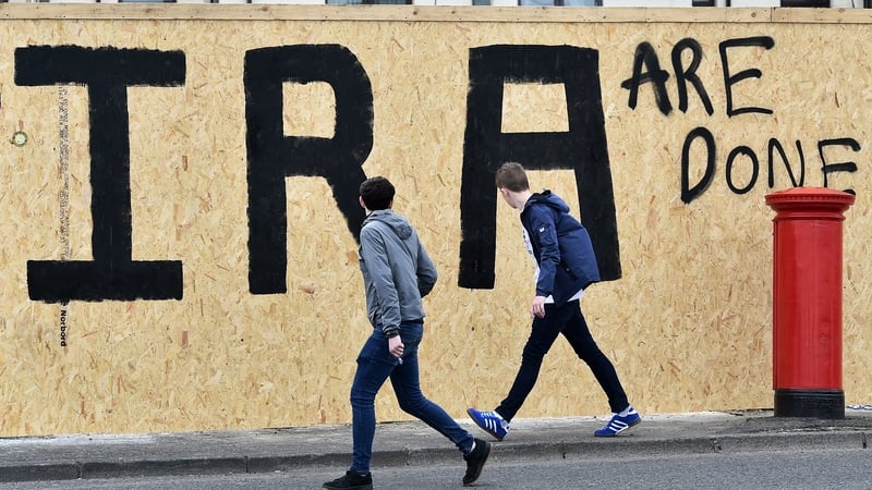Youths walk past anti-IRA graffiti in Derry the day after journalist Lyra McKee was shot dead. Photo: Charles McQuillan/Getty Images