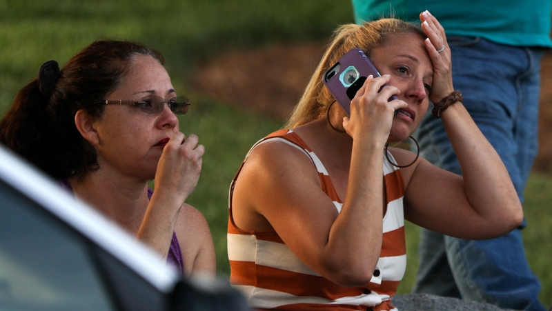 Family and friends gathered near the scene await news after the shooting
