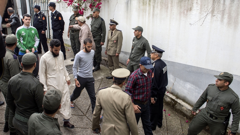 Moroccan police escort a group of the suspects into court