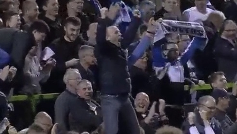 Mike Dean (centre, both arms raised) passionately celebrates at the final whistle