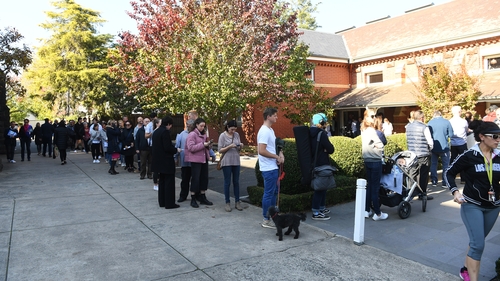 People wait in line to vote outside the Malvern Early Voting Centre in Melbourne yesterday