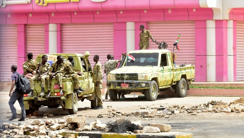 Sudanese soldiers stand guard on a street in Khartoum