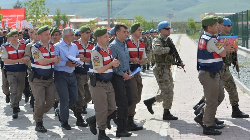 Soldiers escort several of the accused into the court complex at Sincan prison