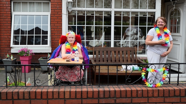 People gather outside their homes to watch the parade