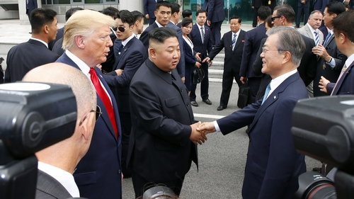 South Korean President Moon-Jae-in shakes hands with Kim Jong-un at the border alongside Donald Trump
