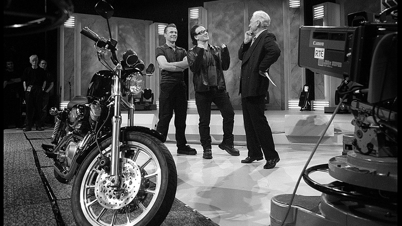Larry Mullen Jr and Bono present Gay Byrne with a Harley Davidson on his last Late Late Show in May 1999