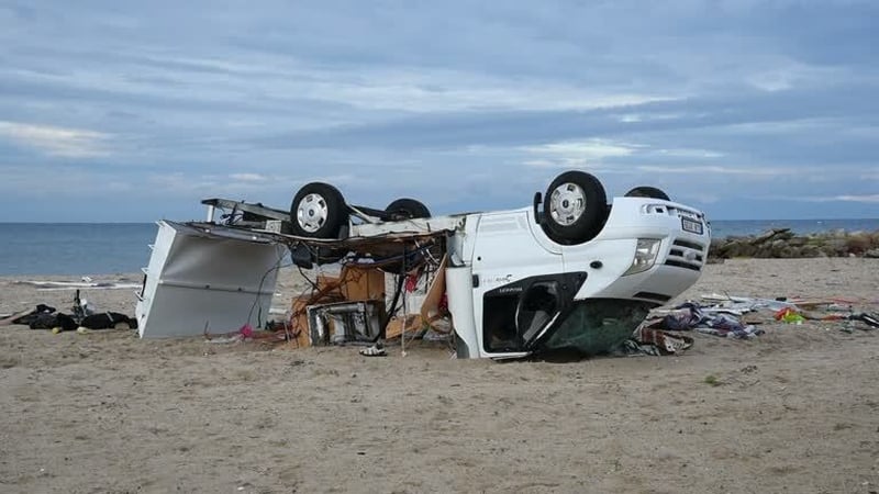 A police officer cordons off a caravan damaged in the storm