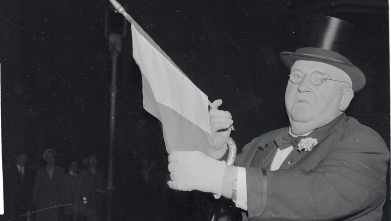 John J. Hanley, the 'Baron of Broadway' holds up an Irish flag in London, where he tried to buy the Northern Ireland from the British.