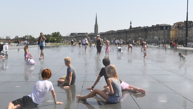 Children cool off at the Water Mirror on the Place de la Bourse in Bordeaux as temperatures reach 42C