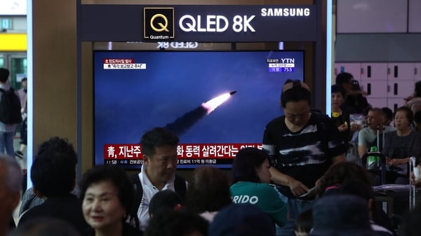 South Koreans watch on a screen a file image of reporting North Korea's missile launch