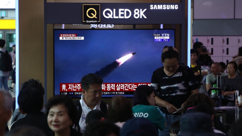 South Koreans watch on a screen a file image of reporting North Korea's missile launch