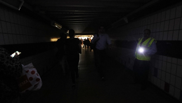 People walk in darkness at Clapham Junction railway station