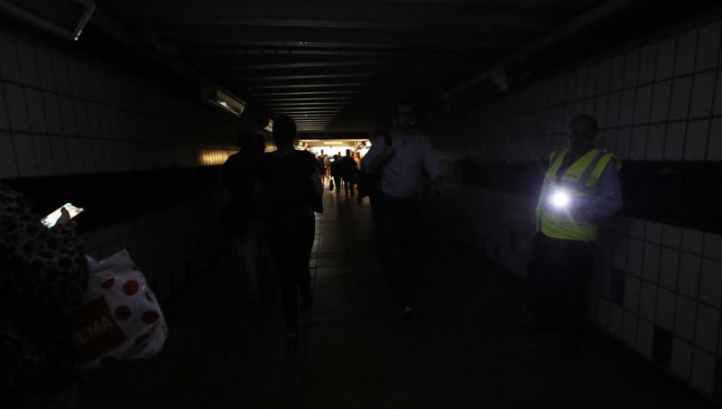 People walk in darkness at Clapham Junction railway station