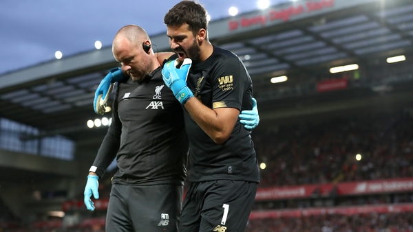 Alisson is helped off the Anfield pitch on the opening day of the season